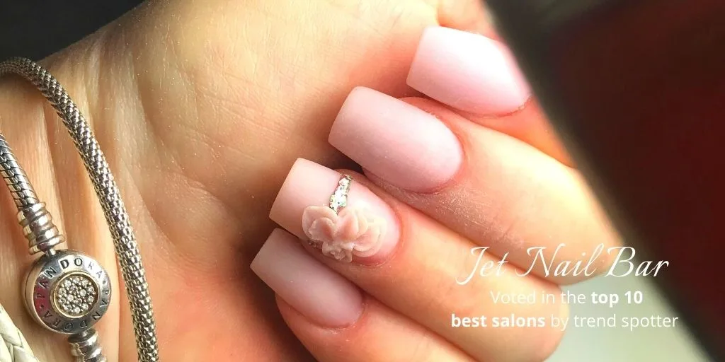 Soft pink matte nails with a sculpted 3D flower accent
