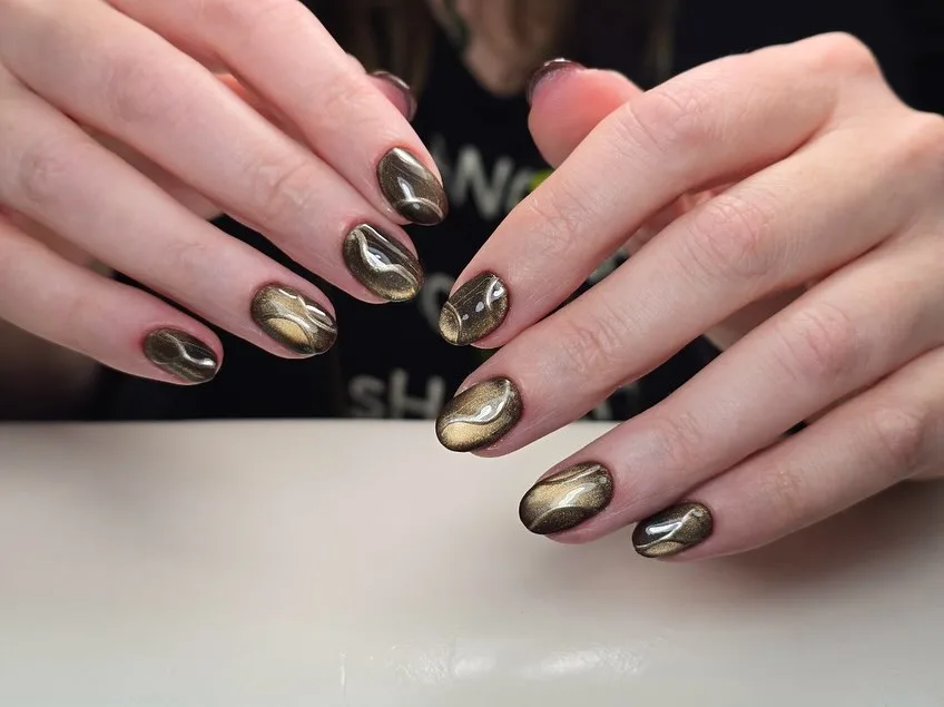 Bronze gold cat-eye chrome nude almond nails on white table