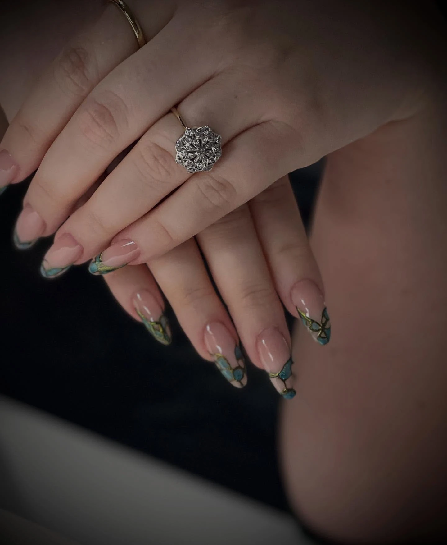 Nude almond nails with teal-gold stained-glass butterfly-wing French tips