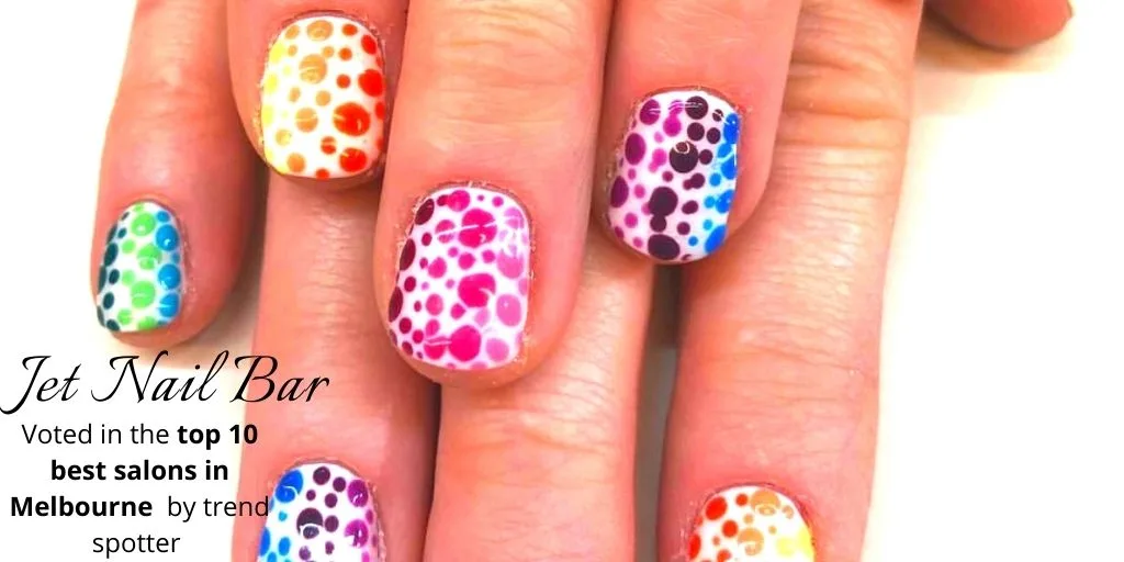 Rainbow polka-dot nail art on white base